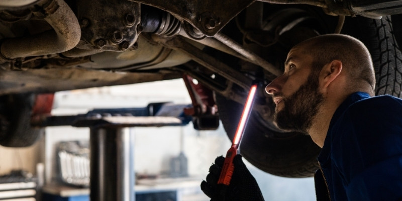 mechanik oglądający auto od spodu