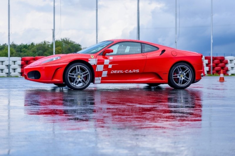 czerwone ferrari na mokrym torze