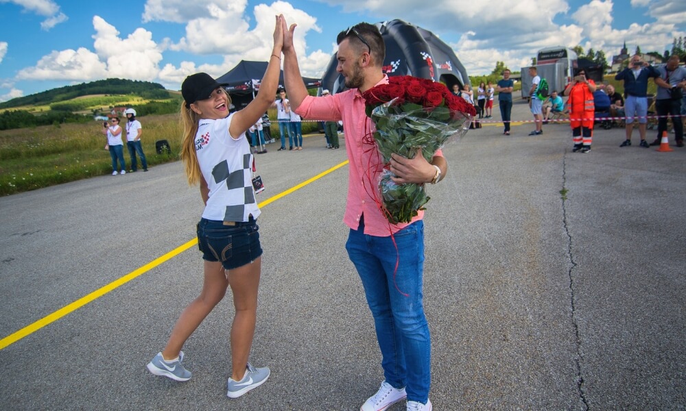 event na torze wyścigowym - kobieta i mężczyzna z kwiatami